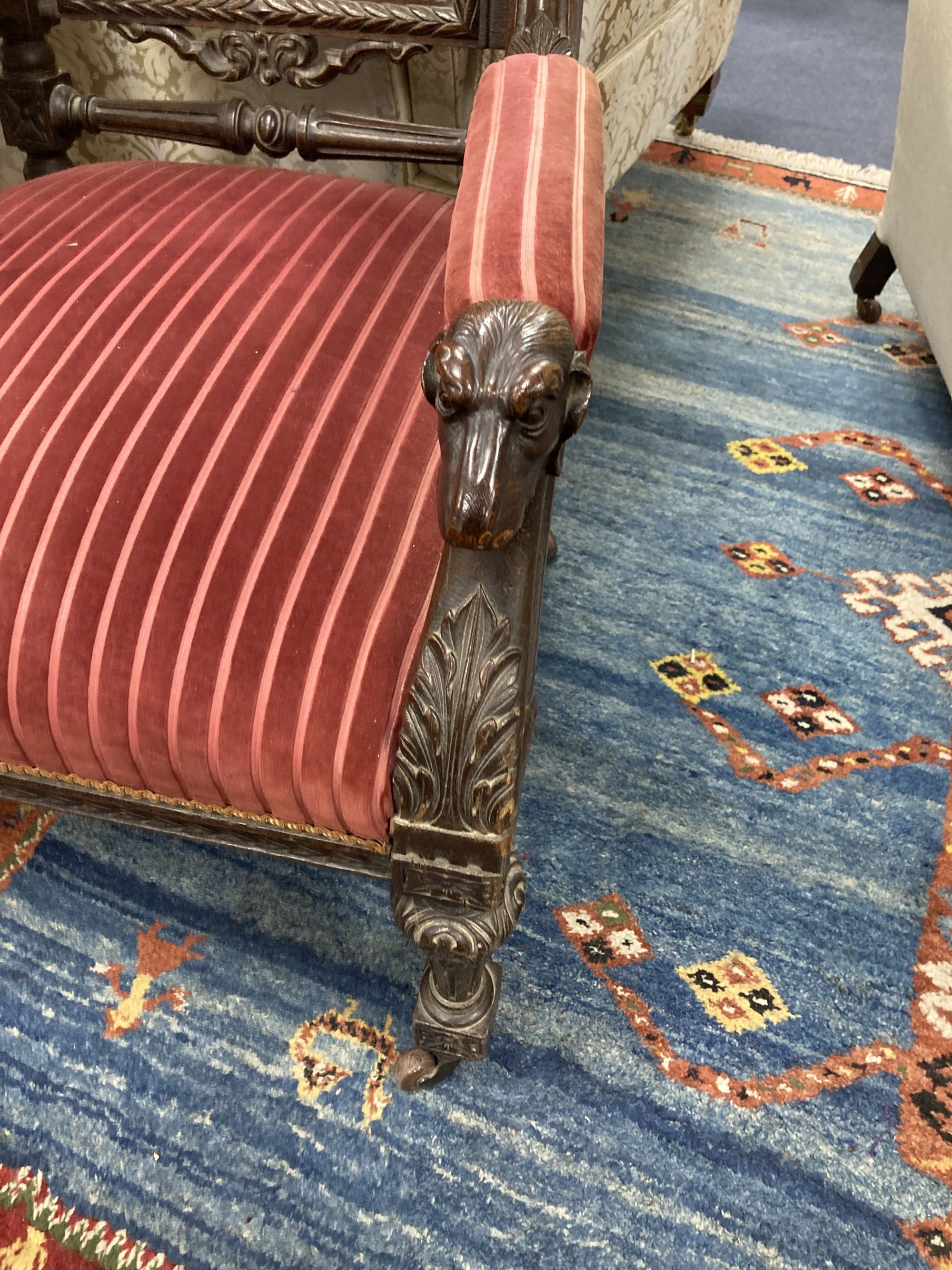 A late 19th century oak Carolean style armchair, with carved dogs head arms, width 68cm, depth 66cm, height 130cm